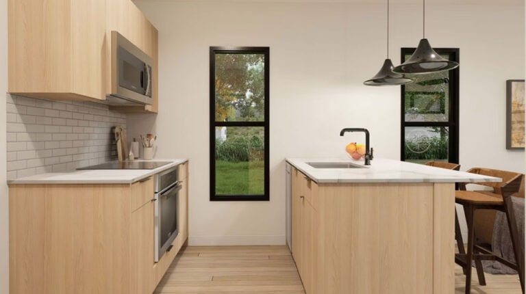 Modern kitchen with natural wood cabinets, white countertops, black faucet, and large windows overlooking a green outdoor space. The space features a minimalist design with a cozy dining area and cont.