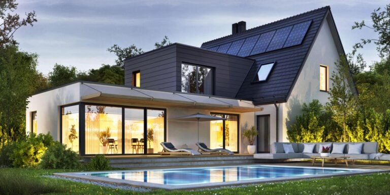 Contemporary house featuring solar panels, large glass windows, outdoor pool, and lush landscaping, showcasing sustainable design and modern architecture.