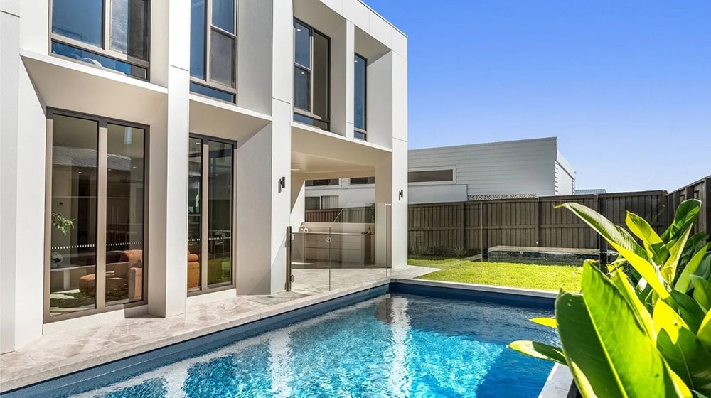 Contemporary residential home with a private swimming pool, large glass windows, and a well-maintained backyard, located in Gold Coast.