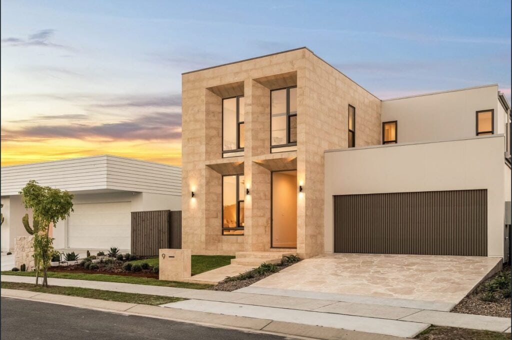 Contemporary house with clean lines, large windows, and a modern facade at sunset, showcasing stylish architecture and landscaping.