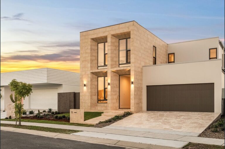 Contemporary house with clean lines, large windows, and a modern facade at sunset, showcasing stylish architecture and landscaping.