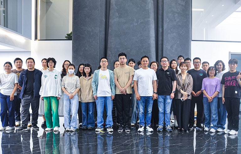 Diverse group of people standing together in a spacious, modern building with high ceilings and large windows, representing teamwork and community.