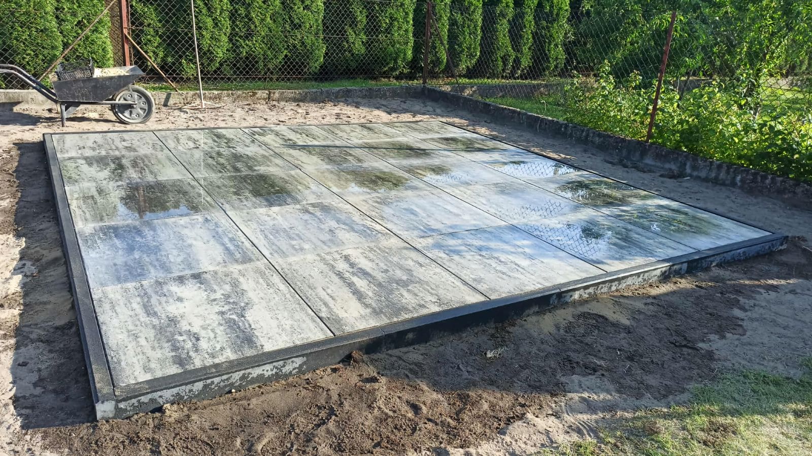 Concrete slab foundation prepared for a prefab home installation, showing a level and reinforced surface ready for construction.