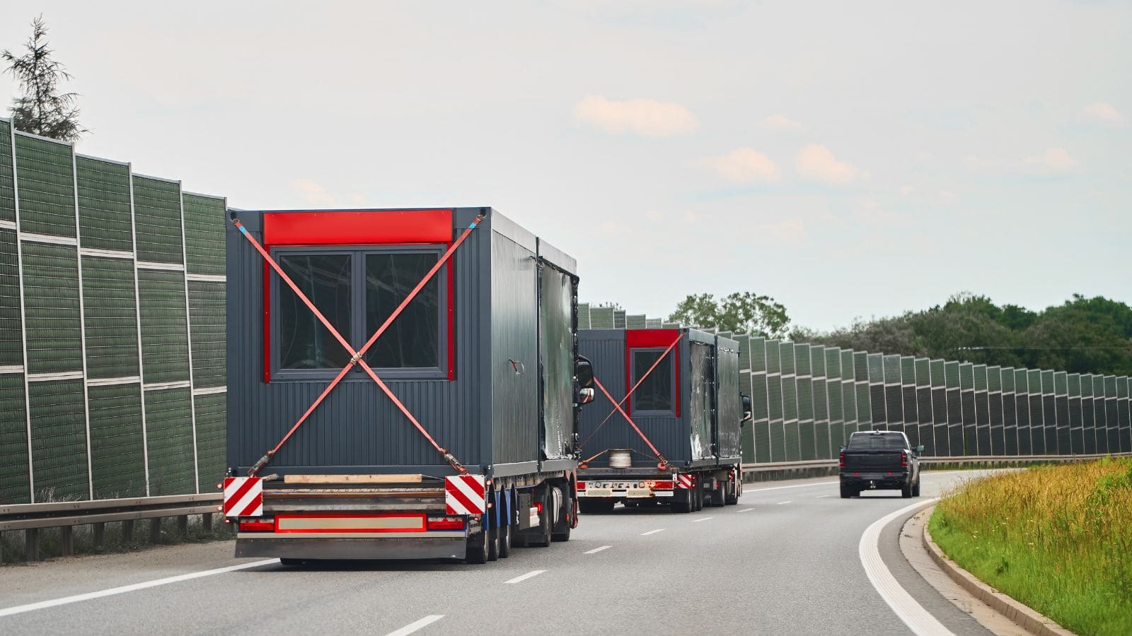 Mobile modular units on a highway, part of offsite construction process for cost reduction in building projects.