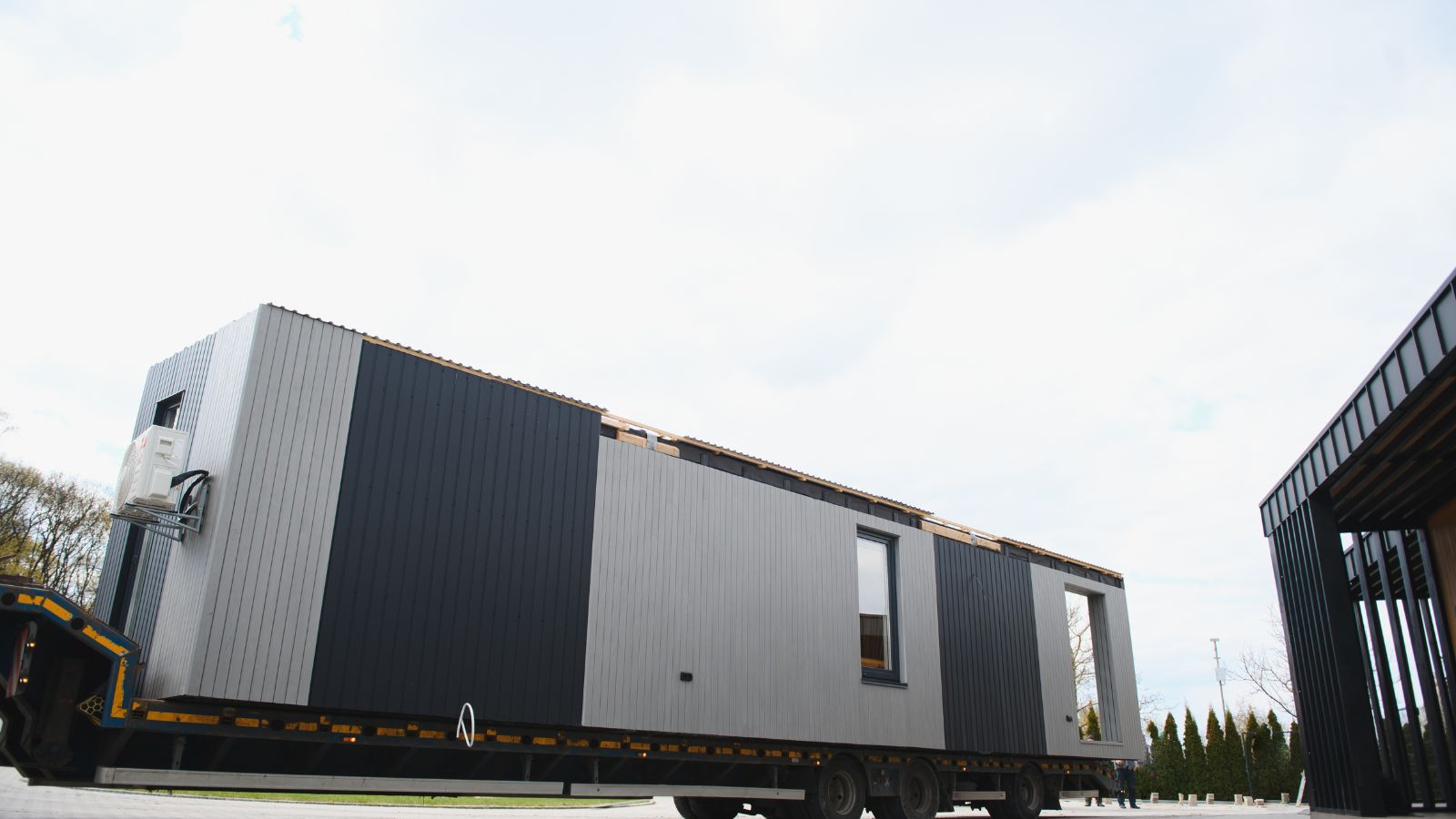 A modular building on a flatbed truck ready for installation, showcasing modern construction techniques and sustainable building solutions.
